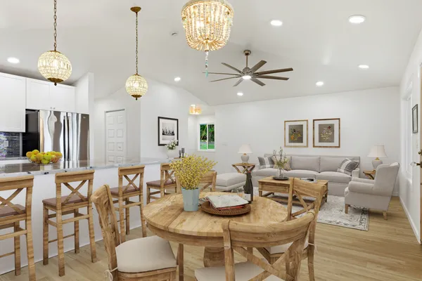 a living room with couches a dining table and chairs with wooden floor