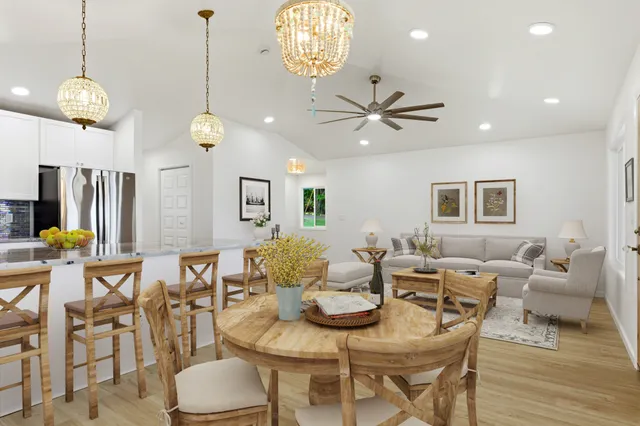 a living room with couches a dining table and chairs with wooden floor