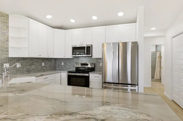 a kitchen with stainless steel appliances granite countertop a refrigerator sink and cabinets