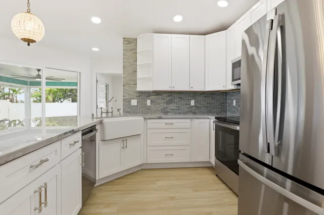 a kitchen with stainless steel appliances white cabinets and a refrigerator