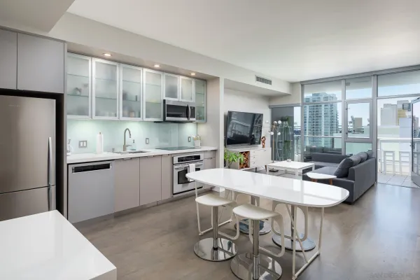 a kitchen with stainless steel appliances kitchen island granite countertop a refrigerator a stove a microwave oven with a dining table and chairs