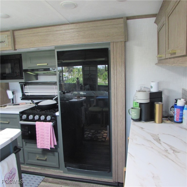 19681-313 Summerlin Road Fort Myers, FL 33908 - Photo 13 of 40 a kitchen with a refrigerator and a stove