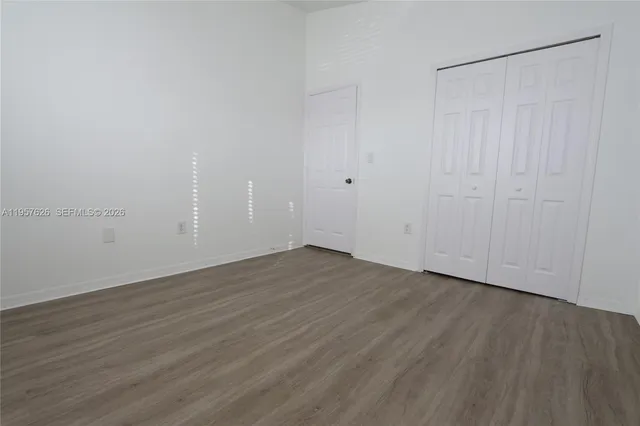 a view of an empty room with wooden floor