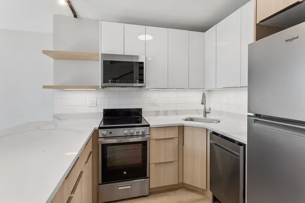 a kitchen with a sink stove and white cabinets