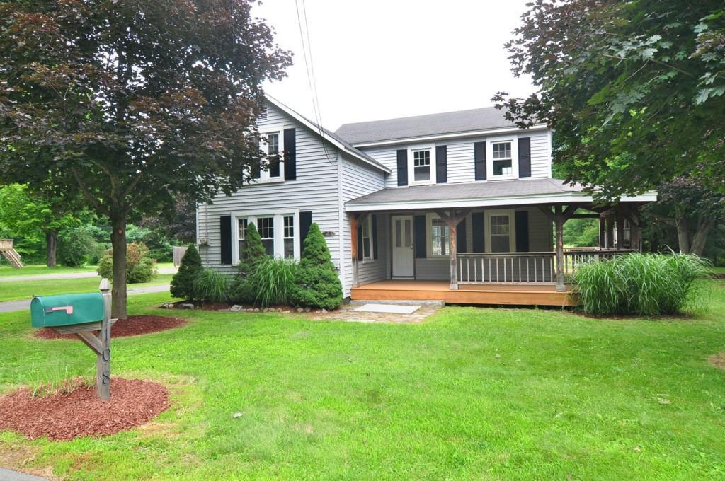 a view of a house with a yard and a large tree