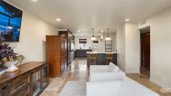 a kitchen with stainless steel appliances granite countertop a sink refrigerator and cabinets