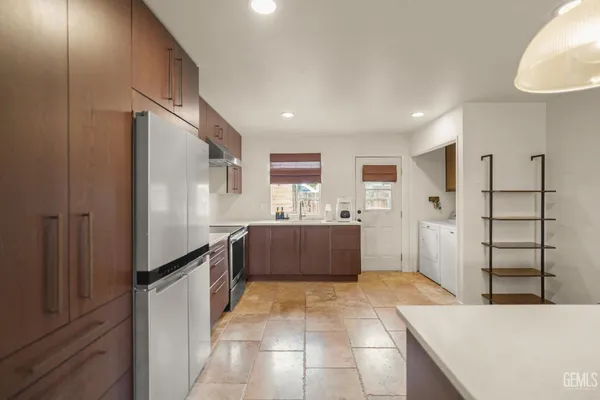 a kitchen with granite countertop a refrigerator and a stove
