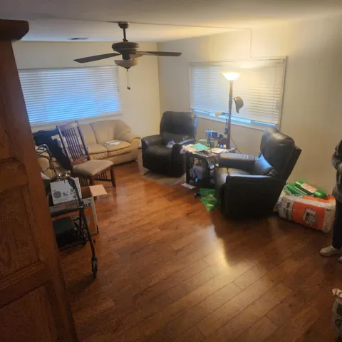 a living room with furniture and a ceiling fan