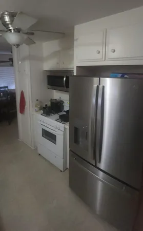 a kitchen with stainless steel appliances granite countertop a refrigerator a stove and a sink