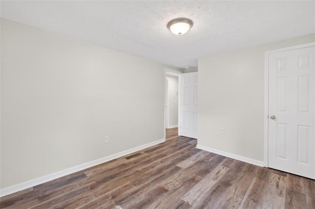 136 Nowell Street Monroe, GA 30655 - Photo 23 of 25 a view of an empty room with wooden floor and a window