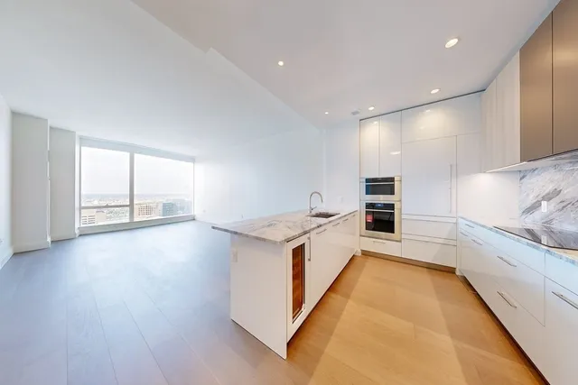 a large white kitchen with cabinets