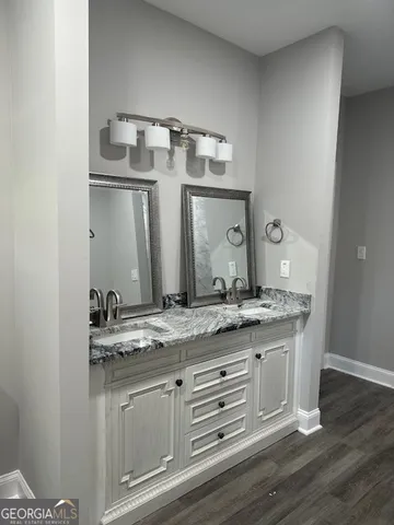 a bathroom with a granite countertop sink and a mirror