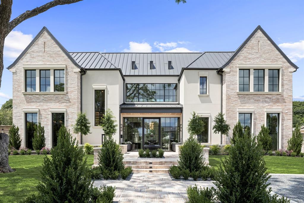 a front view of a house with a garden and plants