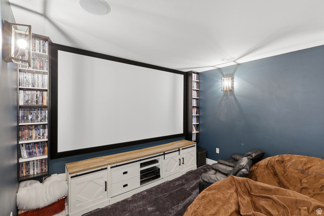 10676 Urban Rdg Cove South Jordan, UT 84095 - Photo 40 of 48 Dedicated media room featuring a large projection screen, built-in media console with barn door detailing, integrated shelving, and recessed ceiling speakers