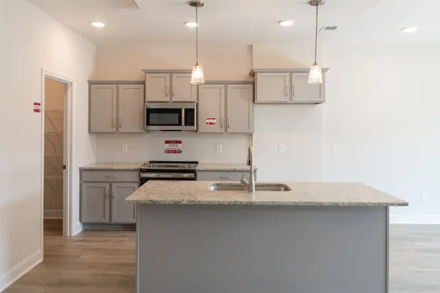 a kitchen with kitchen island a counter space a sink and stainless steel appliances