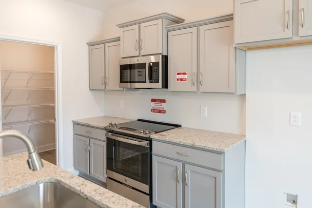 a kitchen with stainless steel appliances granite countertop a sink stove top oven and microwave