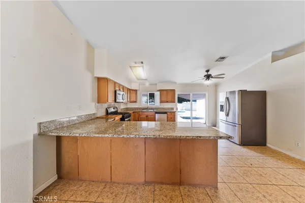 a kitchen with kitchen island granite countertop a counter top space and stainless steel appliances