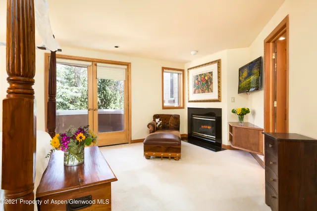 a bed room with a bed a couch and a flat screen tv