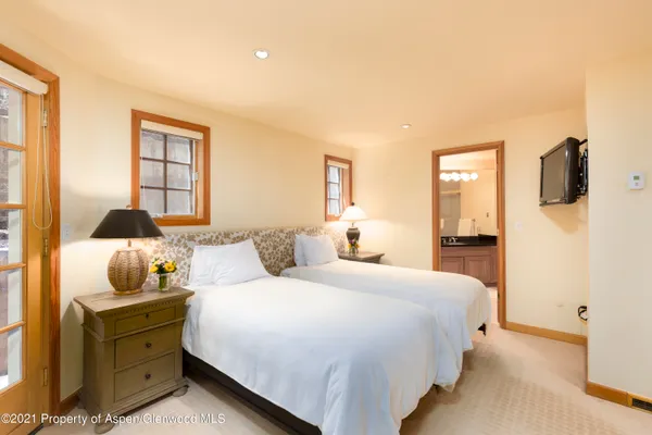 a bedroom with two beds and a large window