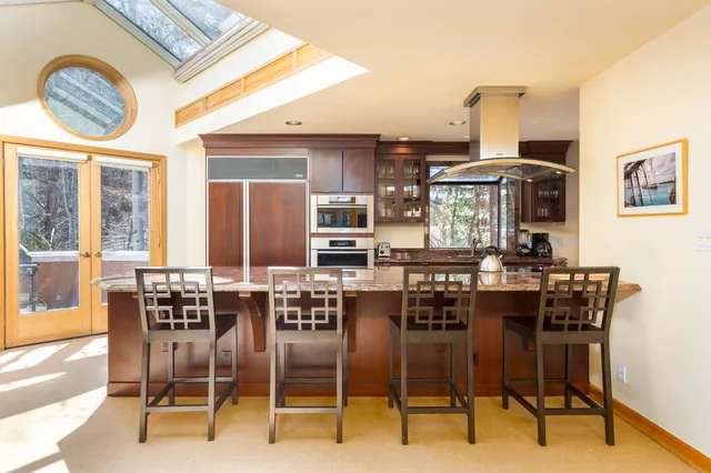 a kitchen with a sink and living room view