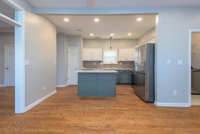 a kitchen with stainless steel appliances granite countertop a stove top oven a sink and a refrigerator