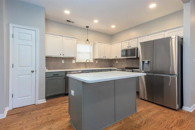 a kitchen with stainless steel appliances granite countertop a refrigerator a sink and a stove