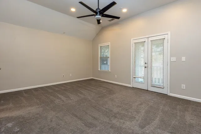 an empty room with fan and windows