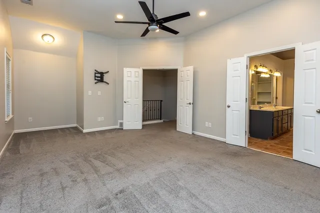 an empty room with closet and a chandelier fan