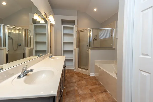 a bathroom with a tub sink and mirror