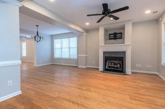 an empty room with windows and fireplace