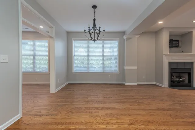a view of an empty room with a window and fireplace