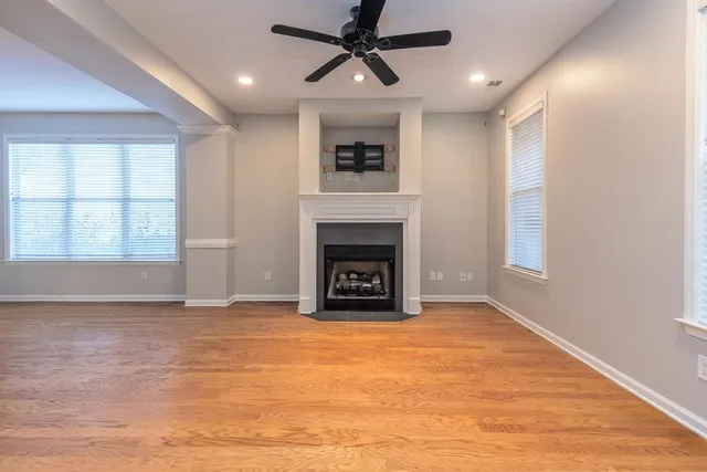 a view of an empty room with a fireplace and a window
