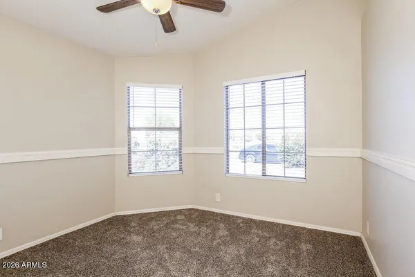 an empty room with windows and fan
