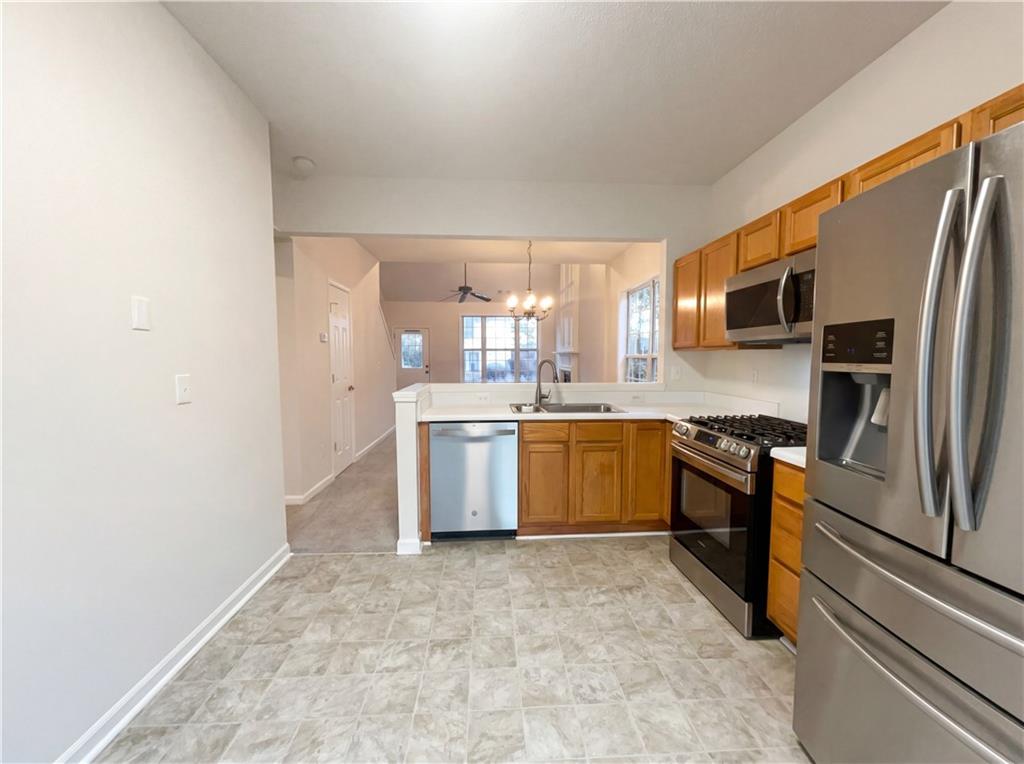 1639 Woodsford Road Kennesaw, GA 30152 - Photo 12 of 31 a large kitchen with a sink stainless steel appliances and cabinets