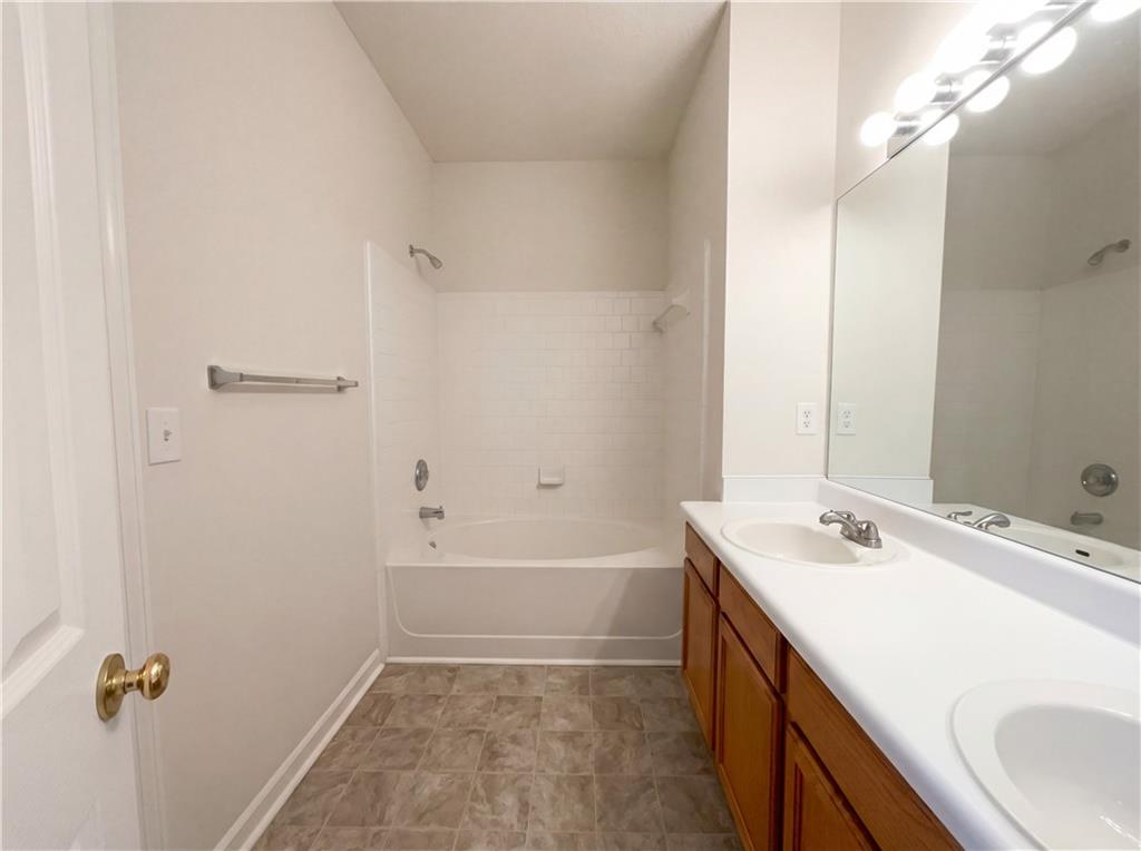 1639 Woodsford Road Kennesaw, GA 30152 - Photo 16 of 31 a bathroom with a sink a tub and a mirror