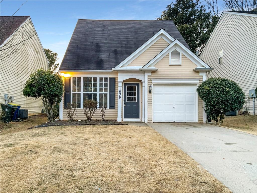 1639 Woodsford Road Kennesaw, GA 30152 - Photo 28 of 31 a front view of a house with a yard and garage