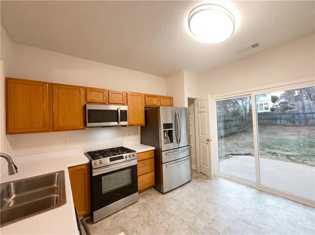 1639 Woodsford Road Kennesaw, GA 30152 - Photo 10 of 31 a kitchen with stainless steel appliances a stove microwave and sink