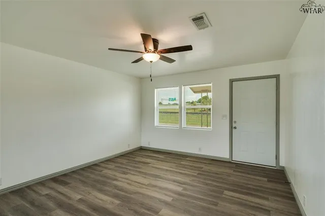 wooden floor in an empty room with a window