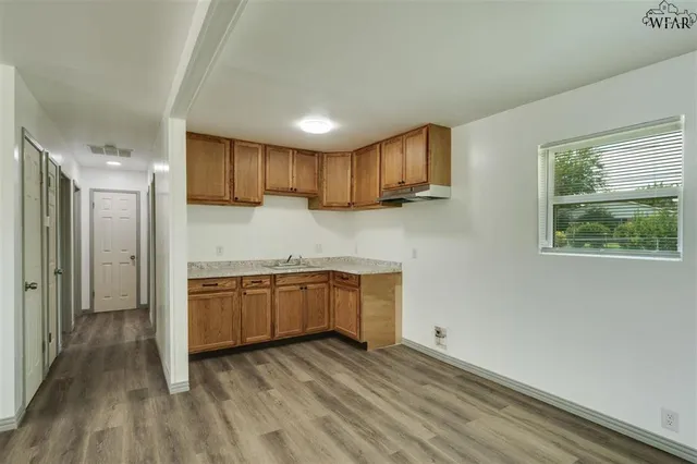 a kitchen with granite countertop a refrigerator and a sink