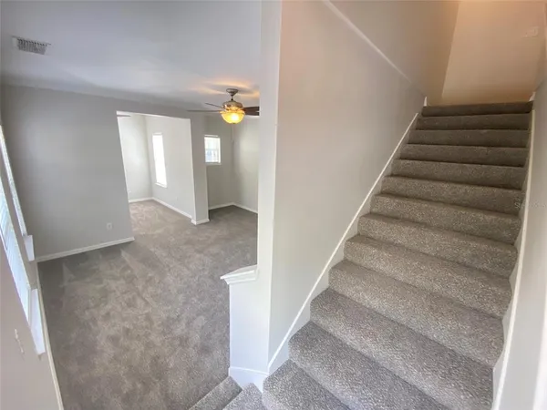 an empty room with a ceiling fan and a window