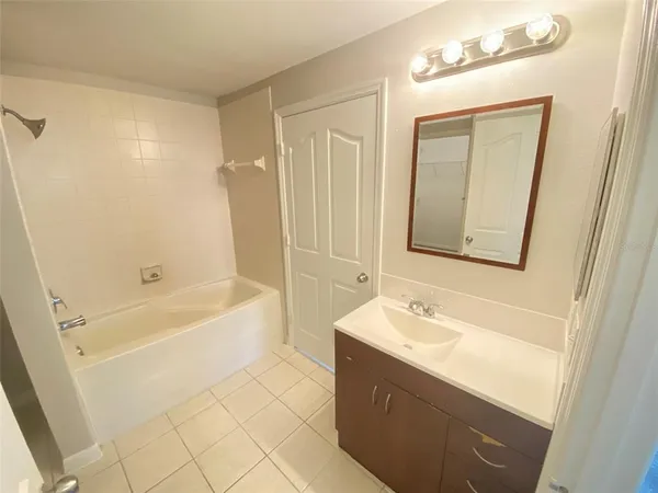 a bathroom with a bathtub a sink a vanity and a mirror
