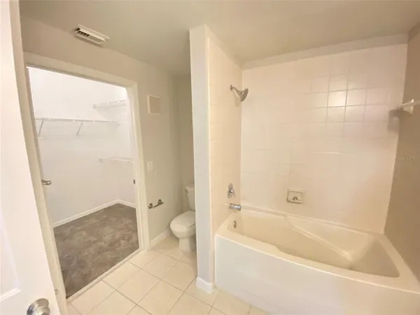 a bathroom with a granite countertop bathtub shower and toilet