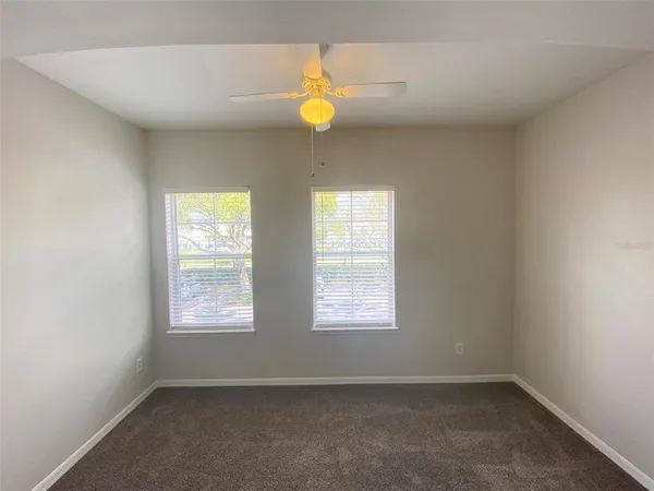 an empty room with windows and chandelier