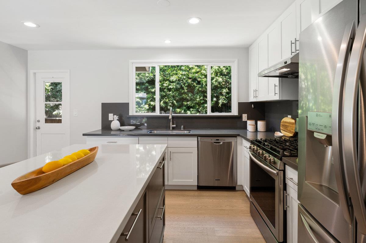 545 Alhambra Road San Mateo, CA 94402 - Photo 14 of 59 a kitchen with a sink a counter top space stainless steel appliances and a window