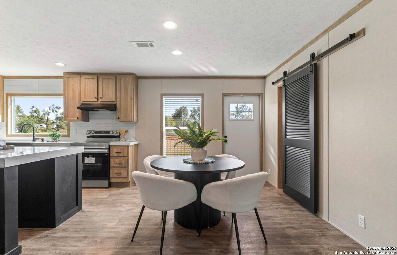Tbd County Road 769 Devine, TX 78016 - Photo 5 of 12 a kitchen with stainless steel appliances granite countertop a stove top oven a sink a refrigerator with a dining table and chairs