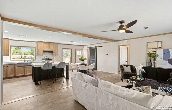 a living room with furniture two window and a flat screen tv
