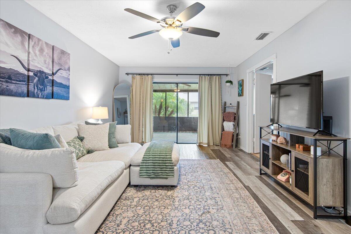 6006 Indrio Road, Unit 7 Fort Pierce, FL 34951 - Photo 3 of 31 a living room with furniture and a flat screen tv