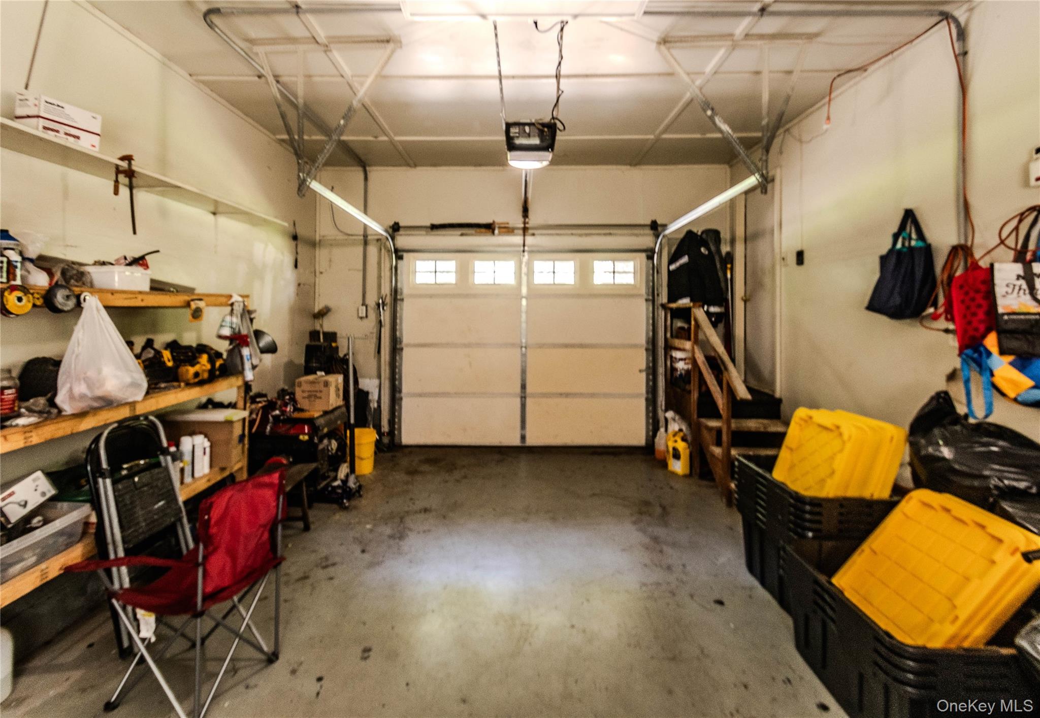 15 Van Dewark Road Middletown, NY 10941 - Photo 34 of 41 Two-car garage featuring a paneled overhead door with upper window inserts, concrete flooring, and built-in shelving