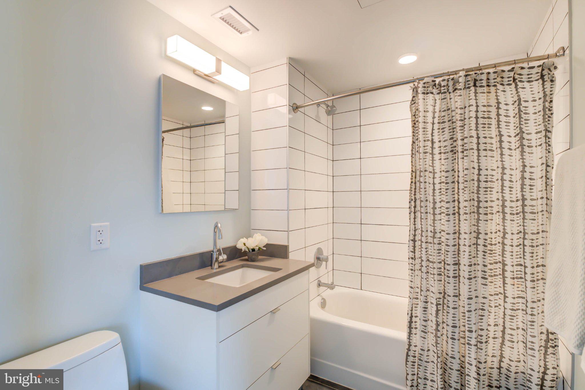 1300 4th Street Southeast, Unit 414 Washington, DC 20003 - Photo 8 of 19 a bathroom with a sink toilet tub and shower