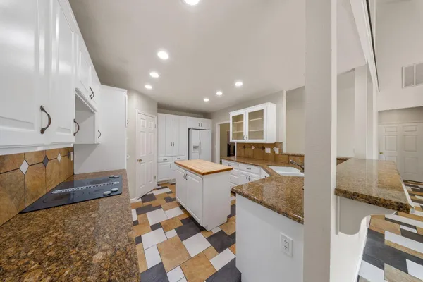 a kitchen with stainless steel appliances granite countertop a sink and a refrigerator